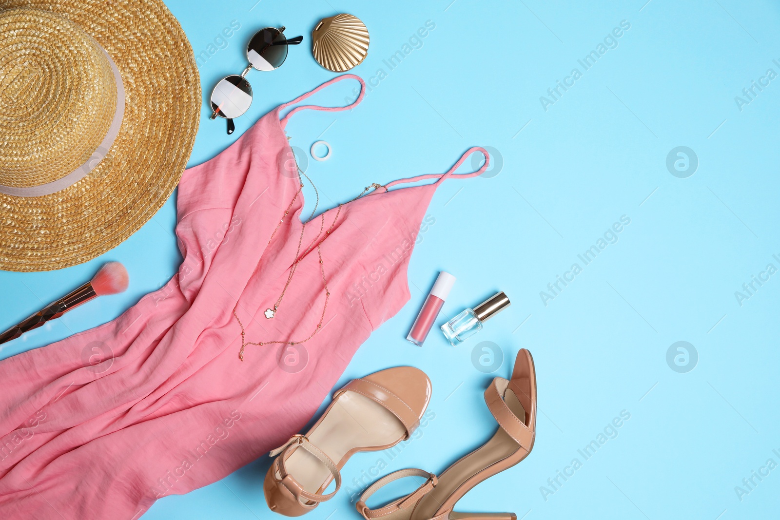 Photo of Stylish women's clothes and different accessories on light blue background, flat lay. Space for text