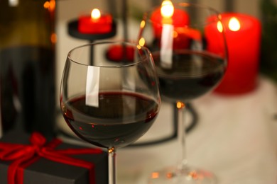 Photo of Glasses of red wine on table, closeup. Romantic dinner