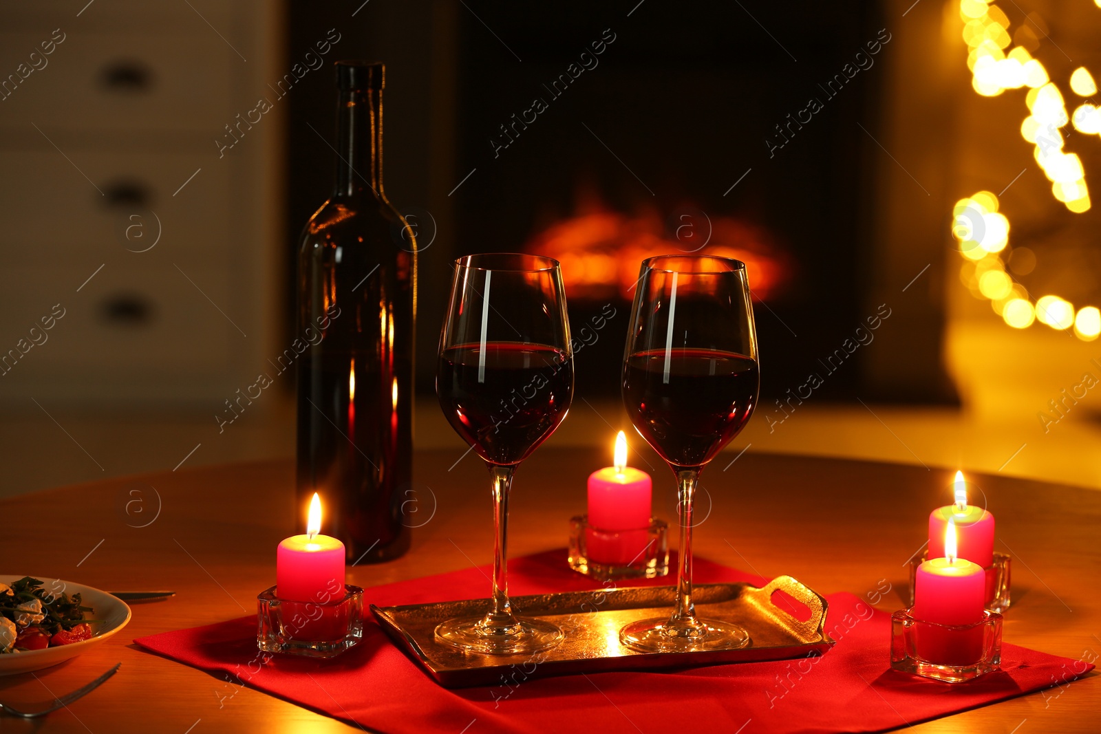 Photo of Glasses of red wine and burning candles on table. Romantic dinner