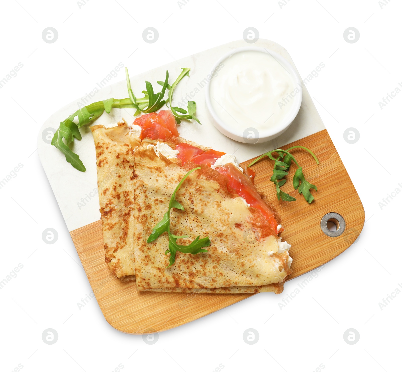 Photo of Delicious crepes with salmon, cream cheese and arugula isolated on white, top view