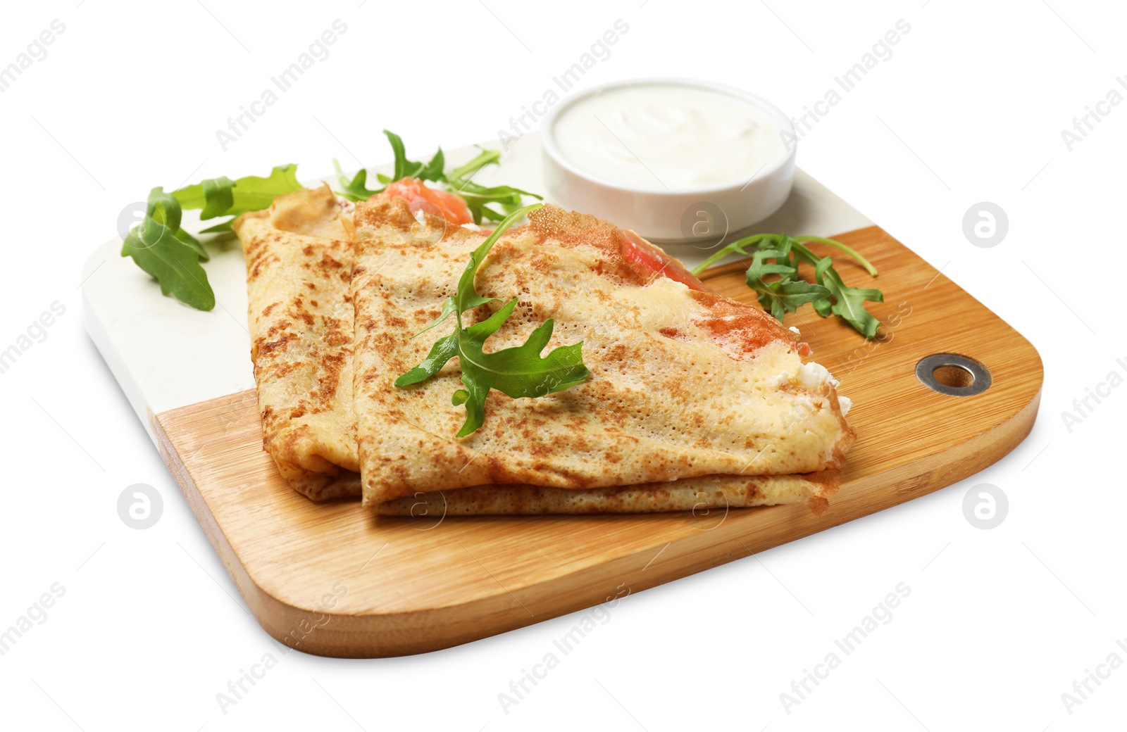 Photo of Delicious crepes with salmon, cream cheese and arugula isolated on white