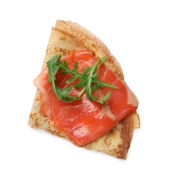 Photo of Delicious crepe with salmon and arugula isolated on white, top view