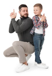 Photo of Father with his cute little son making finger gun gesture on white background