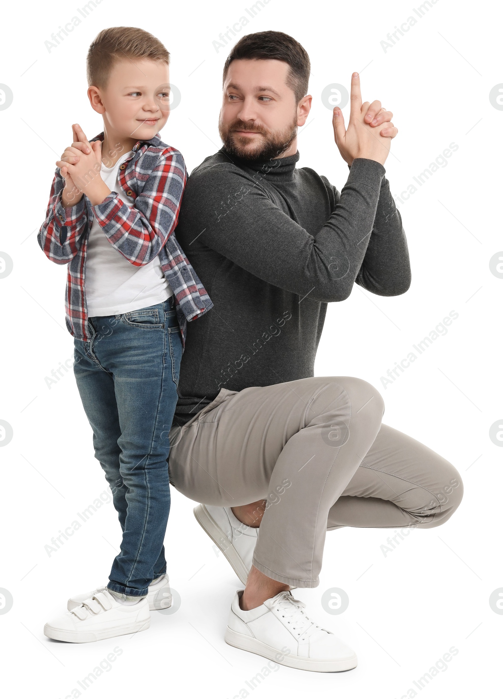 Photo of Father with his cute little son making finger gun gesture on white background