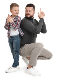 Photo of Father with his cute little son making finger gun gesture on white background