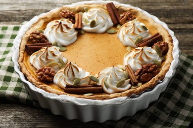 Photo of Tasty homemade pumpkin pie in baking dish on wooden table, closeup