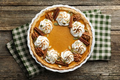 Photo of Delicious homemade pumpkin pie in baking dish on wooden table, top view