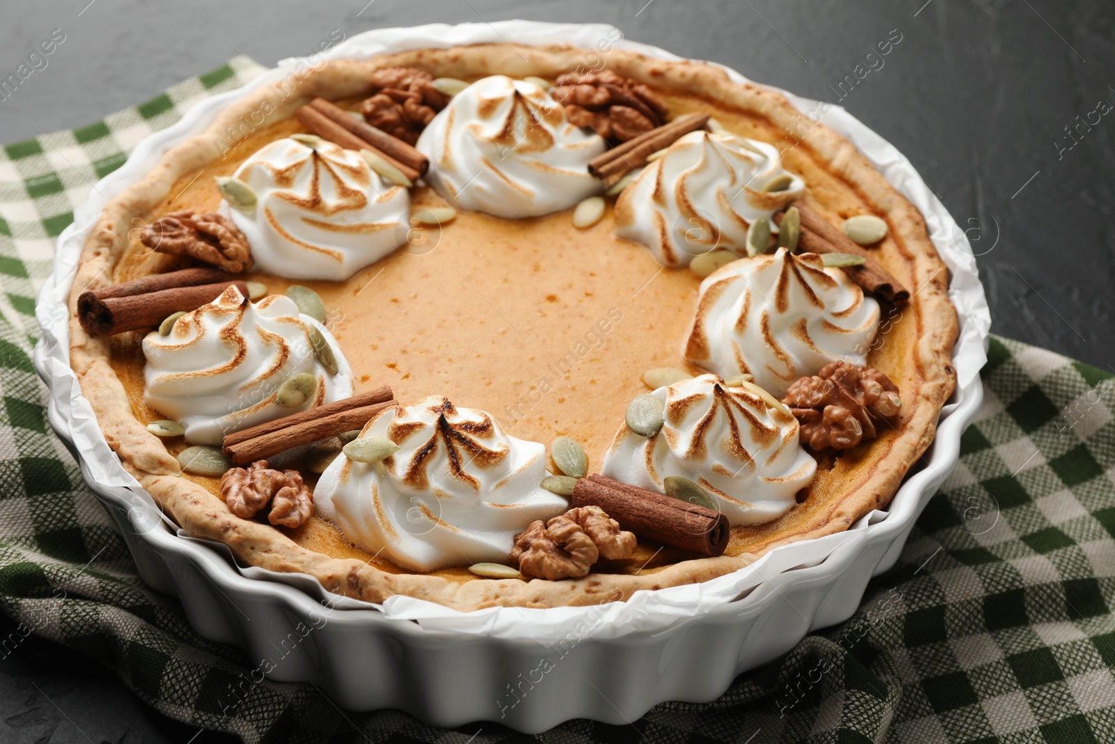 Photo of Delicious homemade pumpkin pie in baking dish on black table, closeup