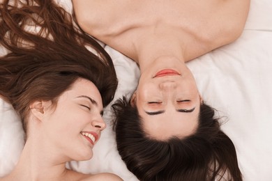 Photo of Spa day. Happy women lying on bed, above view