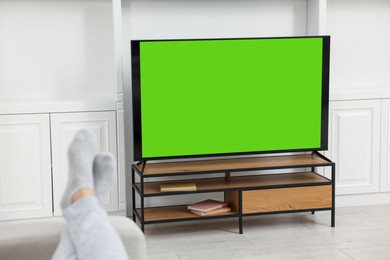 Photo of Man watching TV on sofa at home, closeup