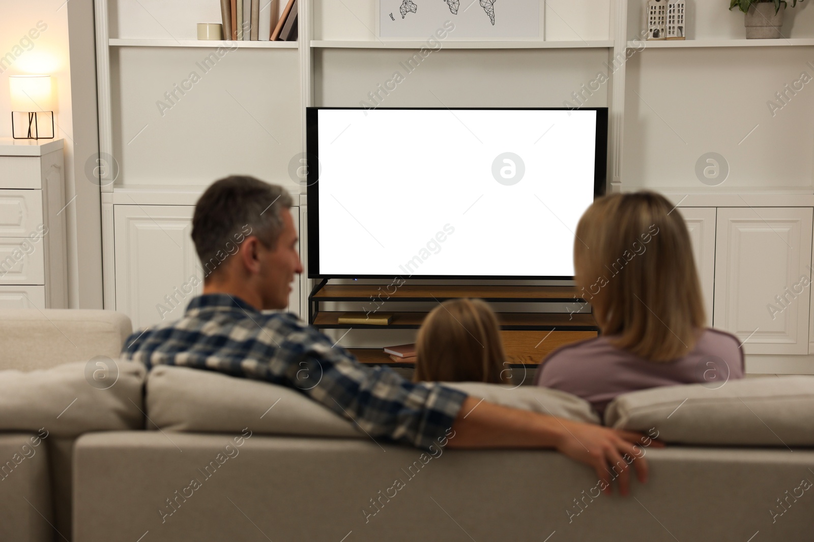 Photo of Family watching TV on sofa at home