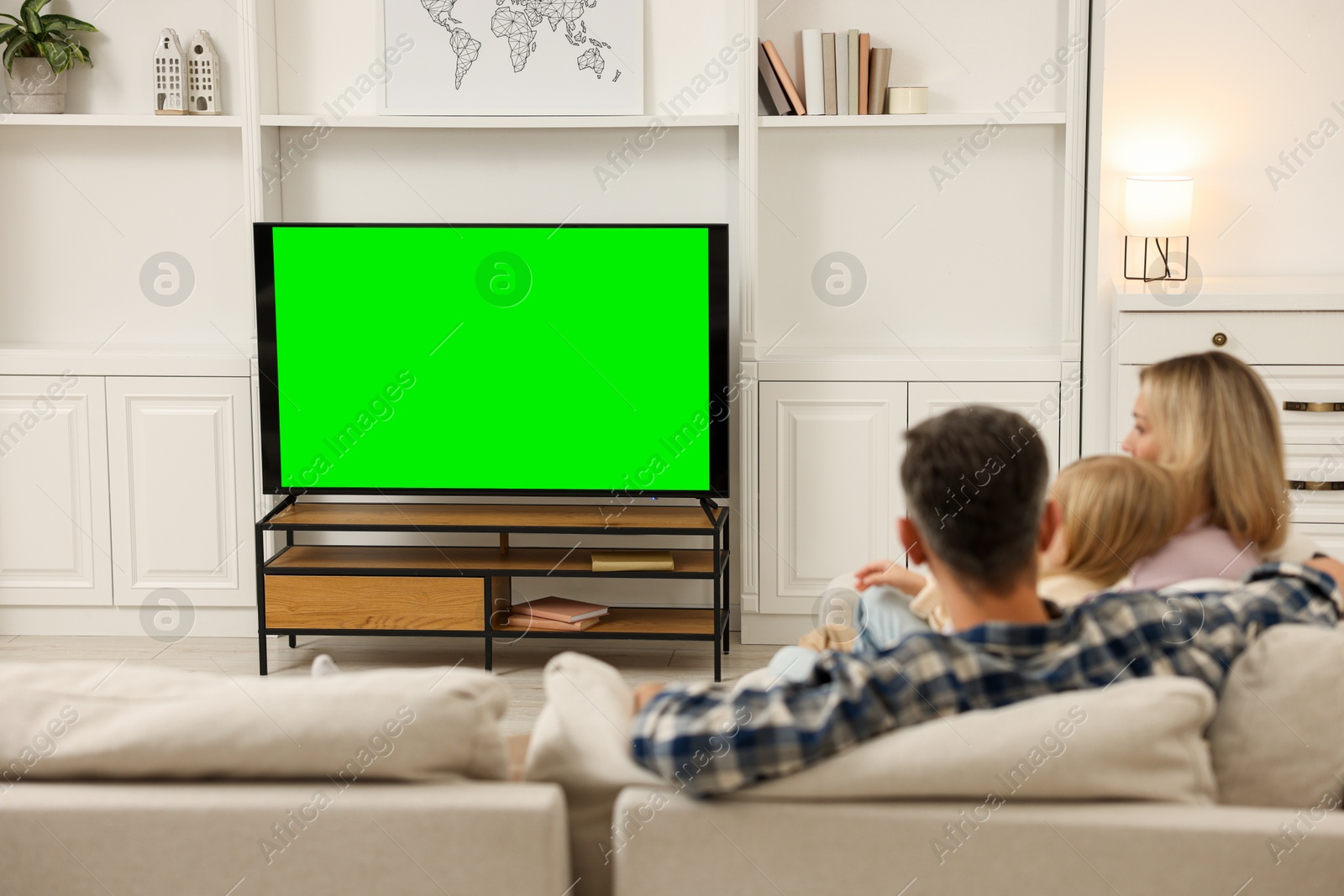 Photo of Family watching TV on sofa at home