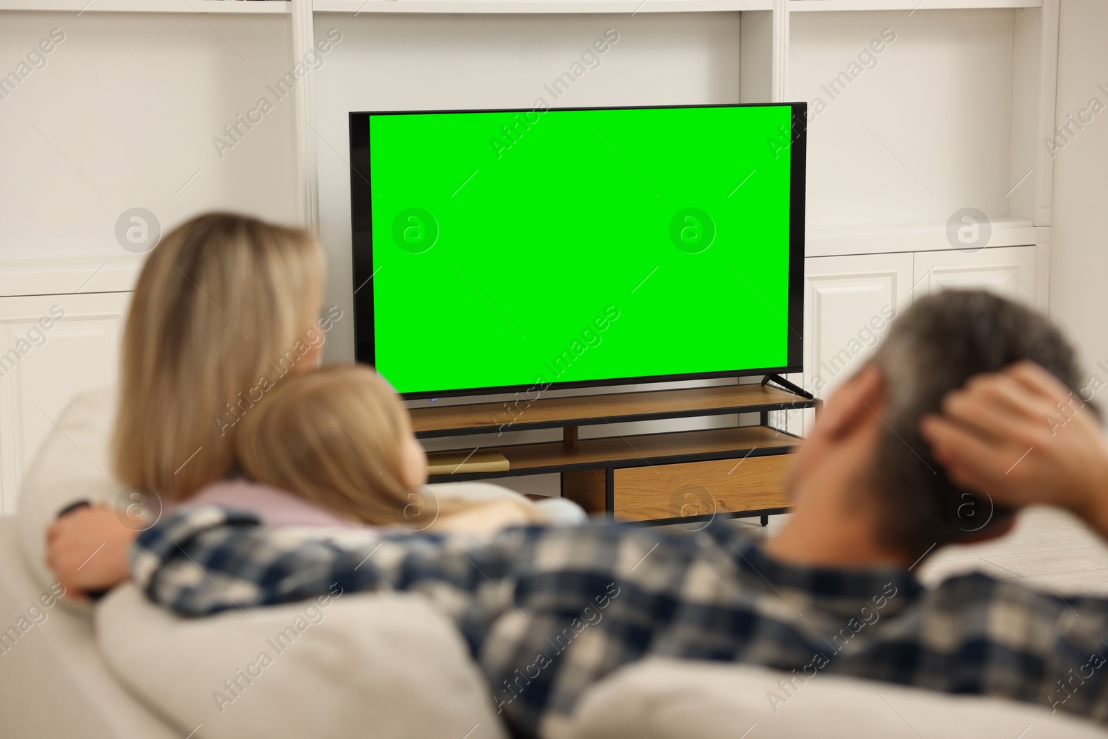 Photo of Family watching TV on sofa at home