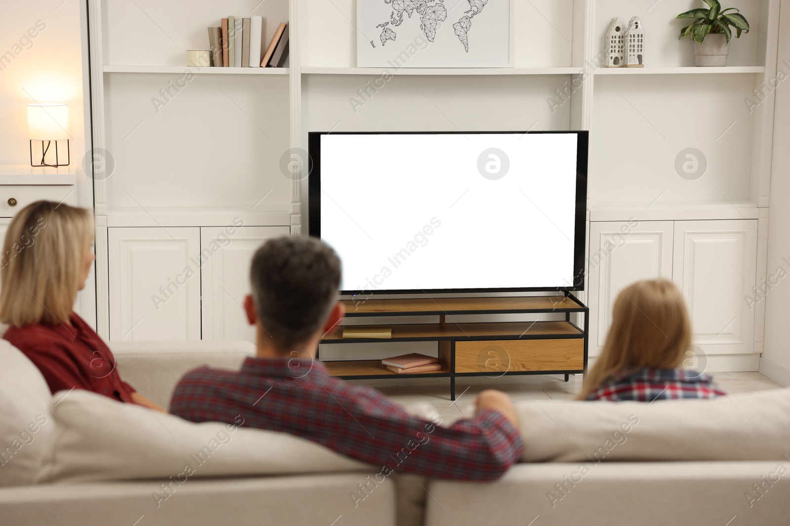 Photo of Family watching TV on sofa at home