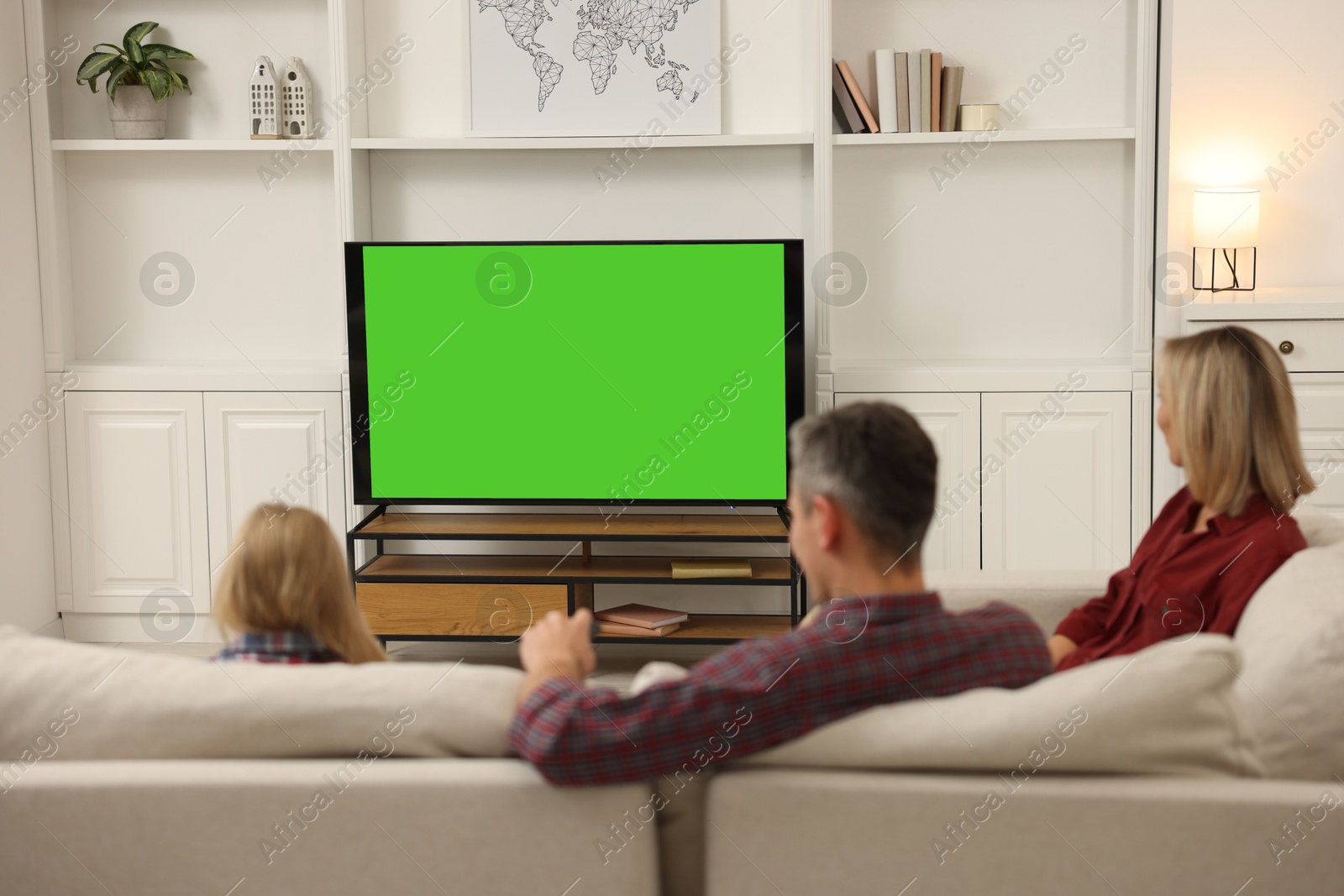 Photo of Family watching TV on sofa at home