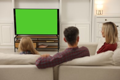 Photo of Family watching TV on sofa at home