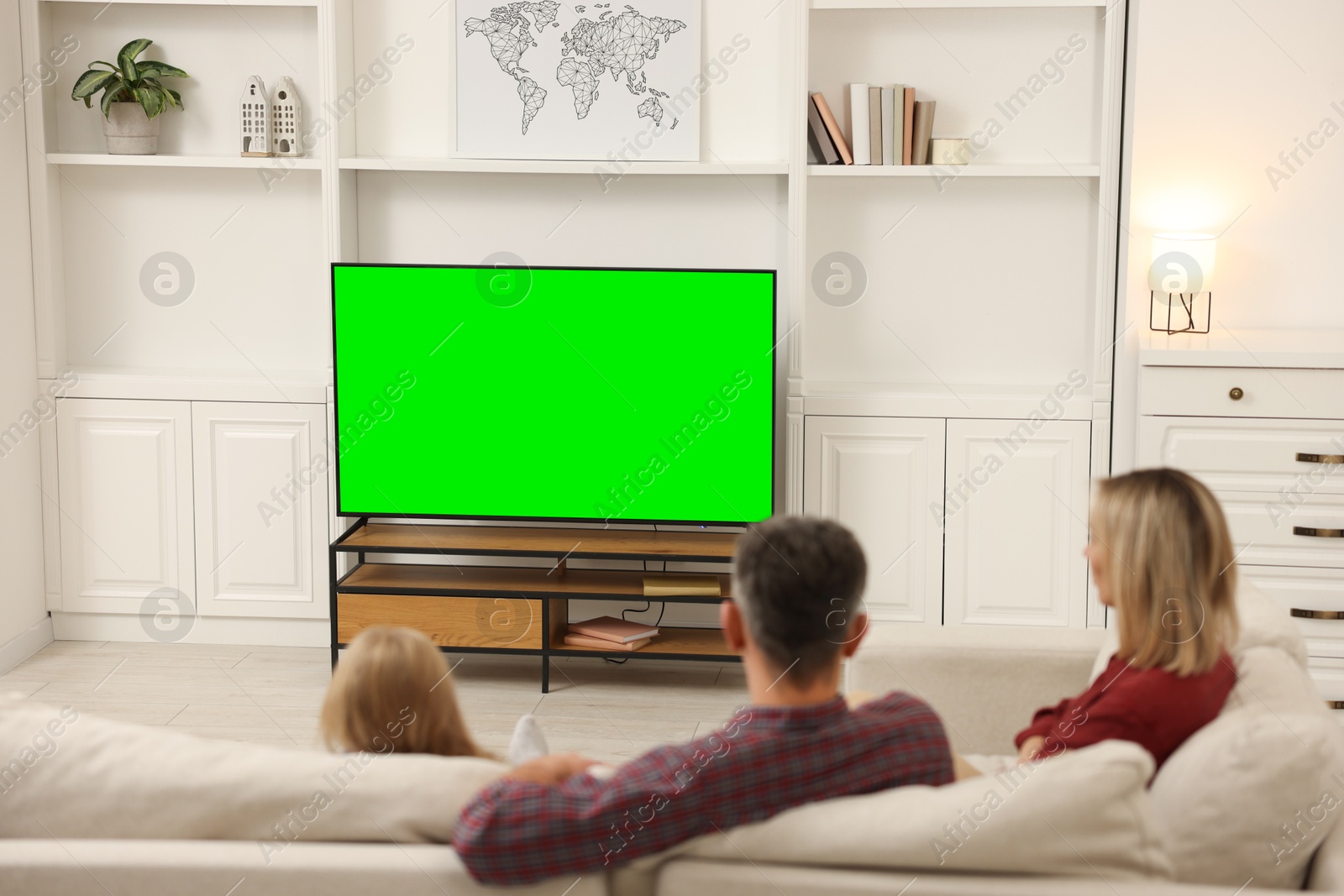 Photo of Family watching TV on sofa at home