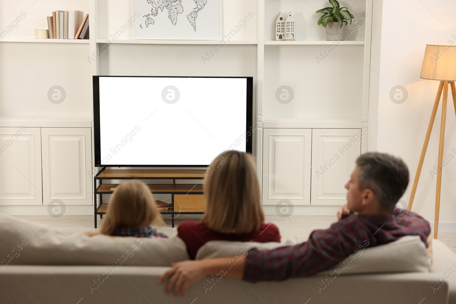 Photo of Family watching TV on sofa at home