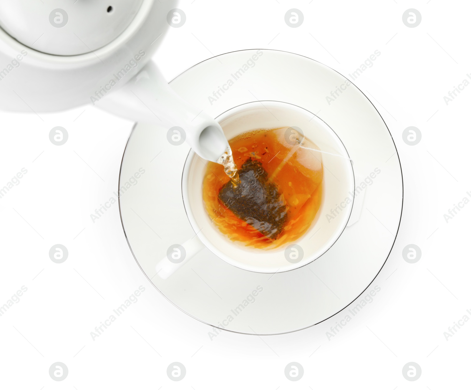 Photo of Pouring hot water into cup with tea bag on white background, top view