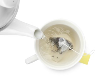 Photo of Pouring hot water into cup with tea bag on white background, top view