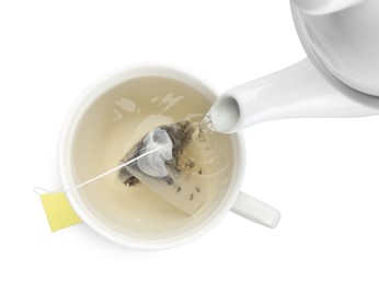 Photo of Pouring hot water into cup with tea bag on white background, top view