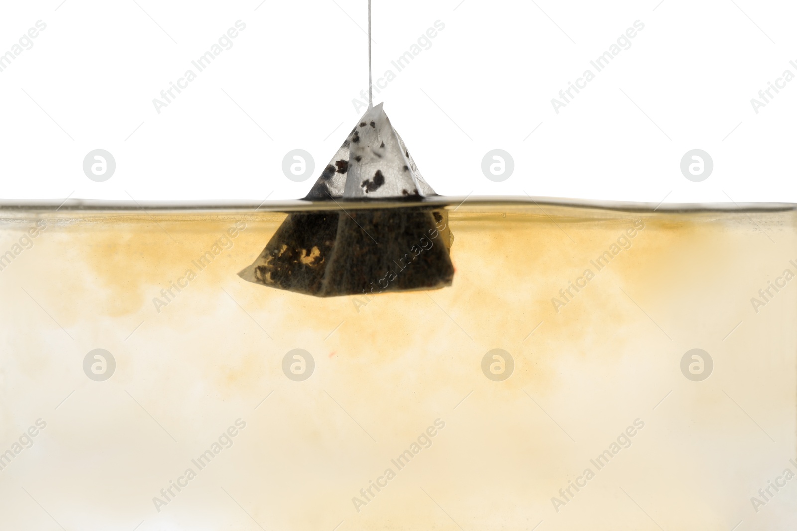 Photo of Putting tea bag into glass cup on white background, closeup