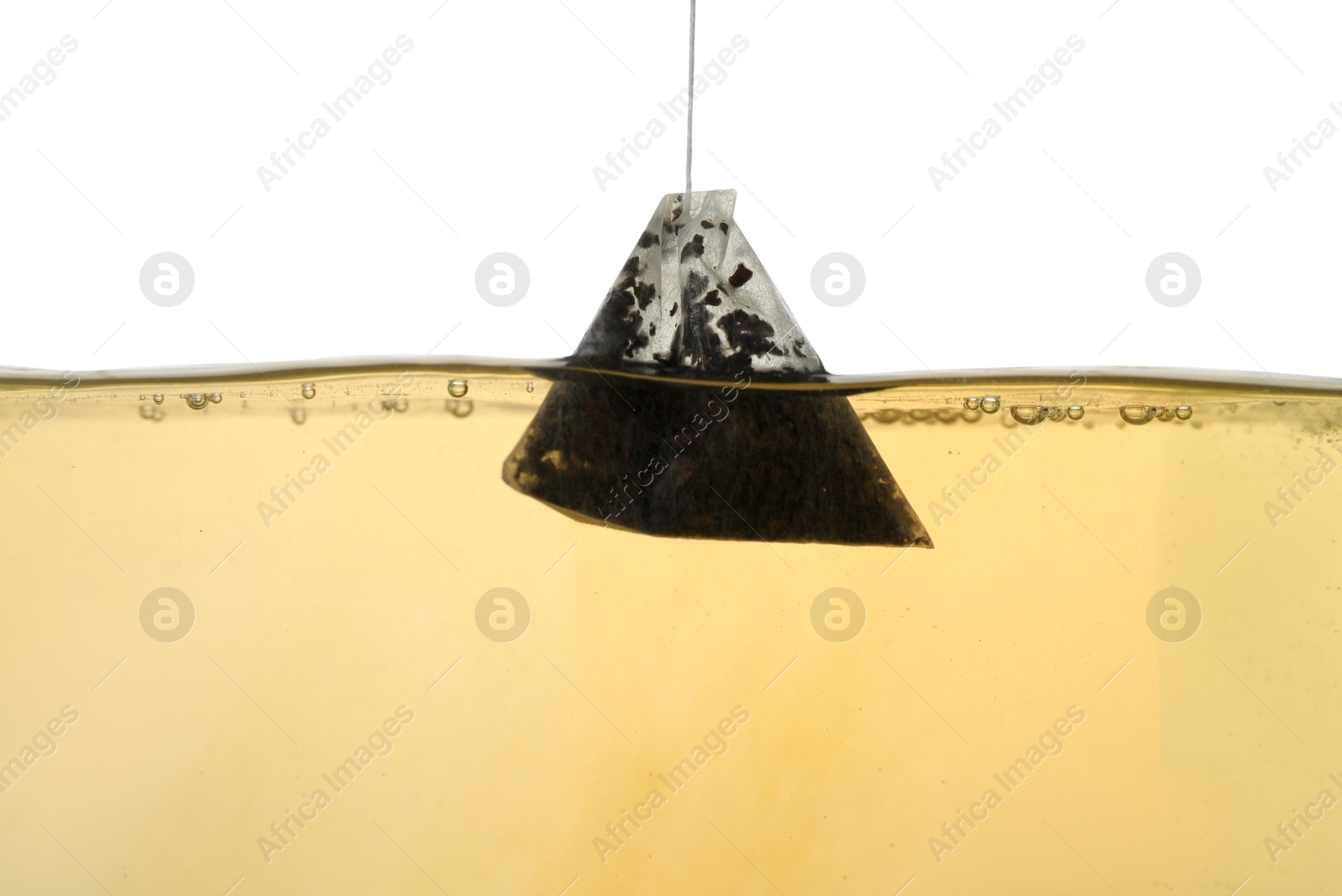 Photo of Putting tea bag into glass cup on white background, closeup