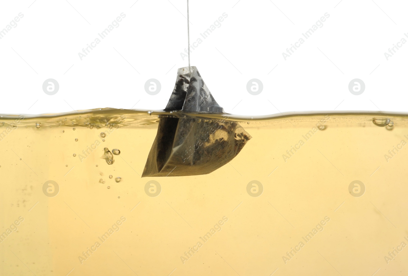 Photo of Putting tea bag into glass cup on white background, closeup