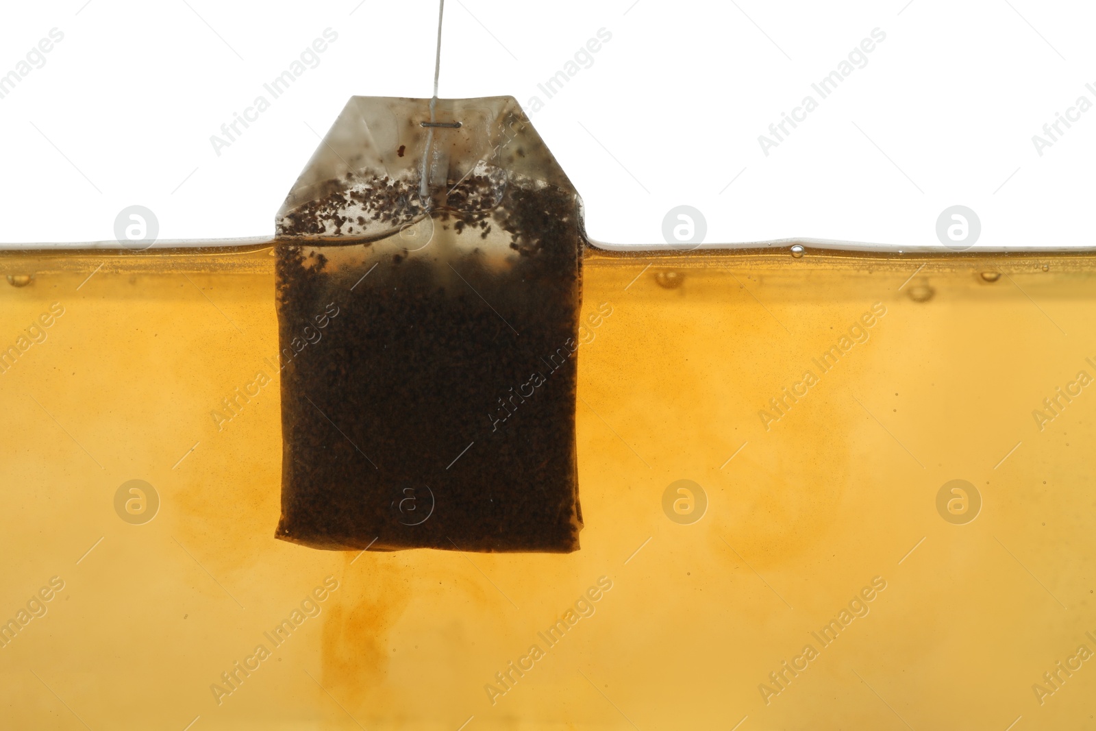 Photo of Putting tea bag into glass cup on white background, closeup