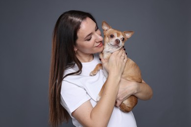 Photo of Beautiful woman with her cute Chihuahua dog on grey background