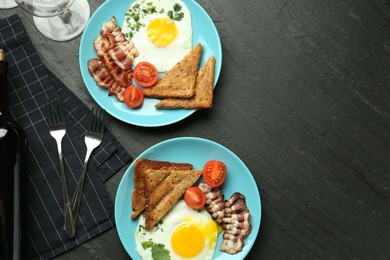 Photo of Tasty food and wine served for brunch on black table, flat lay. Space for text