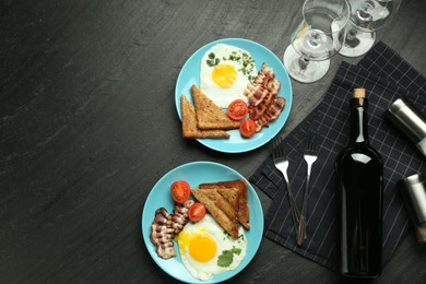 Photo of Tasty food and wine served for brunch on black table, flat lay. Space for text