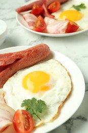 Photo of Tasty brunch. Fried egg, sausage and tomato on white marble table, closeup