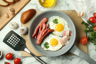 Photo of Tasty brunch. Fried eggs, sausages, bacon and other products on white marble table, flat lay