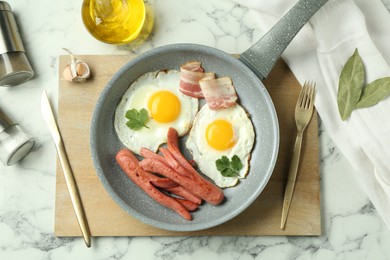 Photo of Tasty brunch. Fried eggs, sausages and bacon served on white marble table, flat lay