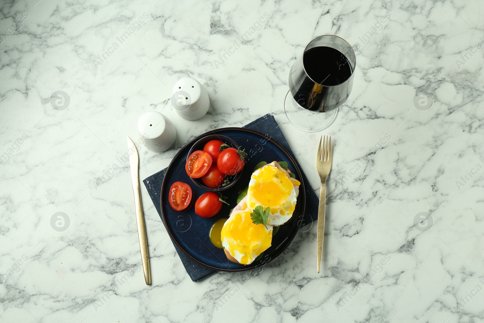 Photo of Tasty brunch. Poached eggs, bun and tomatoes served on white marble table, flat lay