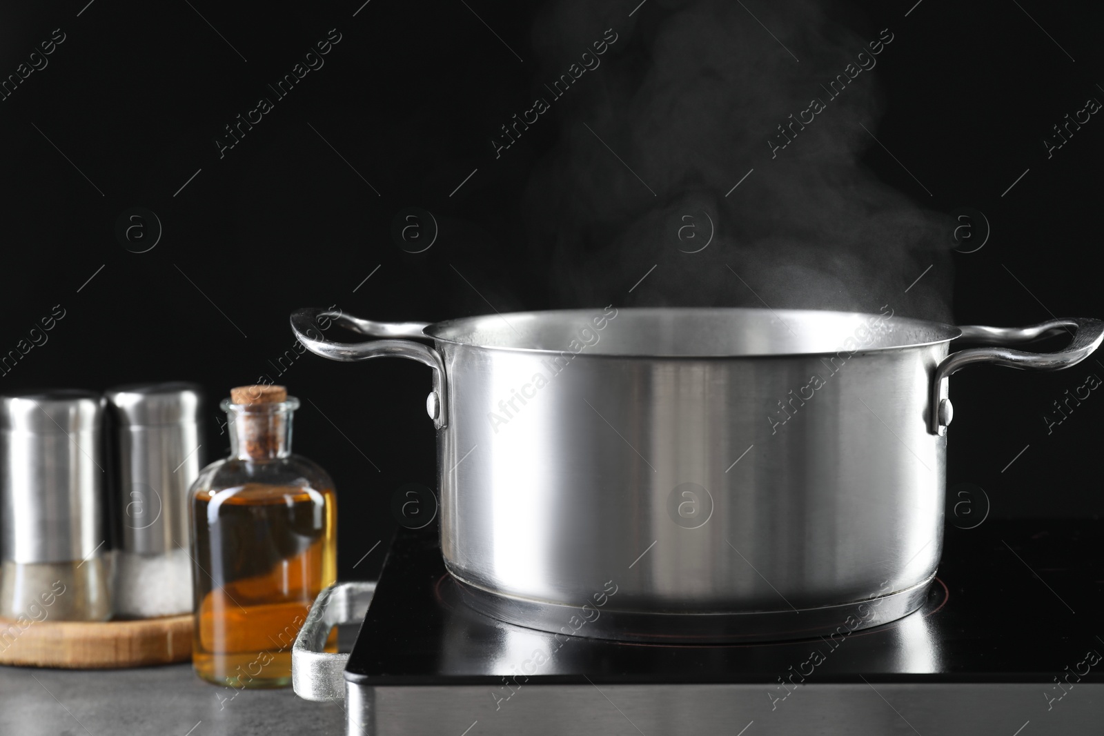 Photo of Metal pot on stove against black background