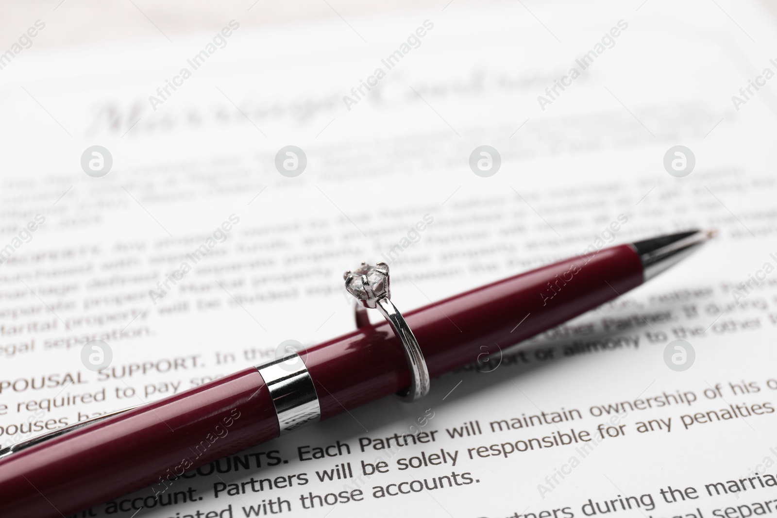 Photo of Marriage contract, pen and stylish ring on marriage contract, closeup