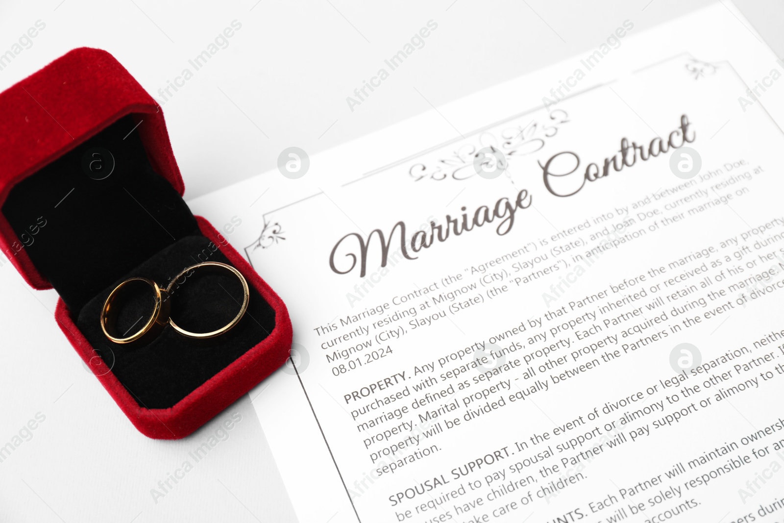 Photo of Marriage contract and golden rings on grey table, closeup