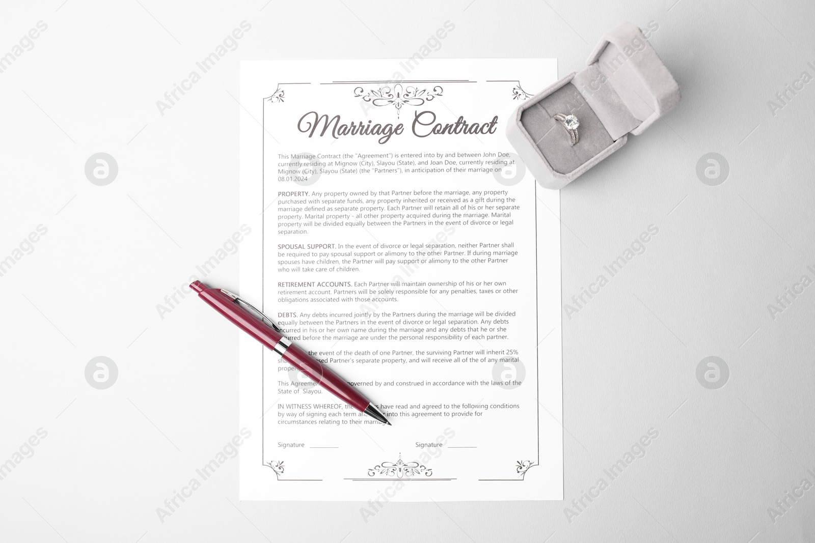 Photo of Marriage contract, pen and ring on grey table, top view