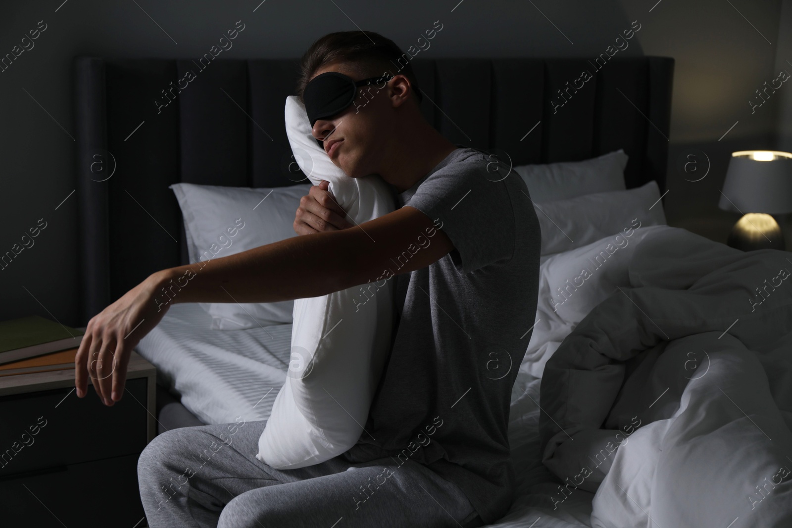 Photo of Young man suffering from sleepwalking on bed at home