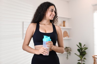 Photo of Beautiful woman with protein shake at home