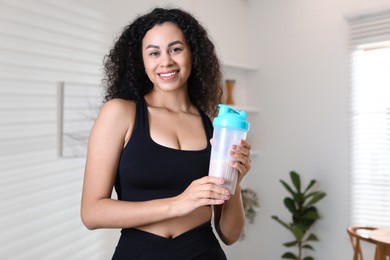 Beautiful woman with protein shake at home