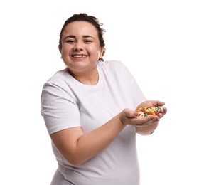 Photo of Happy plus size woman holding pile of weight loss supplements on white background