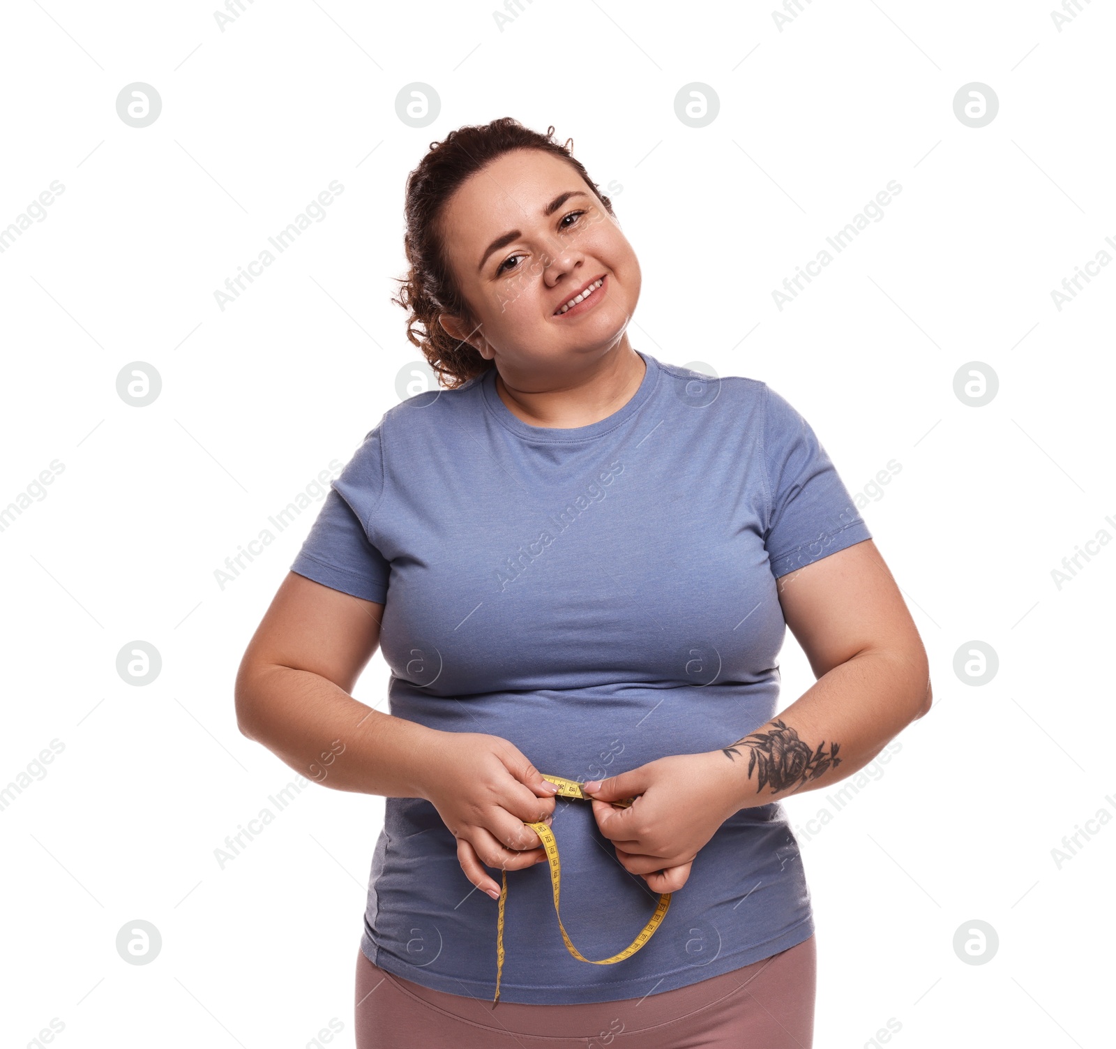 Photo of Weight loss. Happy plus size woman measuring waist with tape on white background