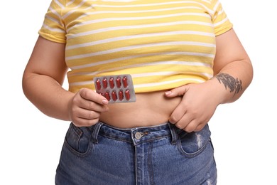 Photo of Plus size woman with blister of weight loss supplements on white background, closeup