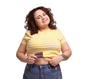 Photo of Happy plus size woman with blister of weight loss supplements on white background