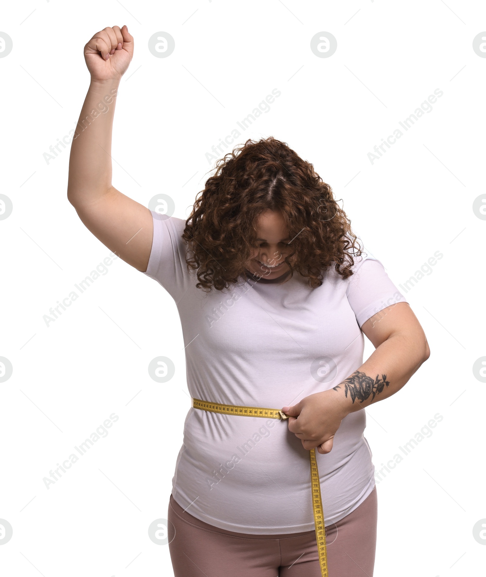 Photo of Weight loss. Happy plus size woman measuring waist with tape on white background