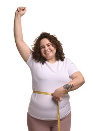 Photo of Weight loss. Happy plus size woman measuring waist with tape on white background