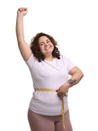 Photo of Weight loss. Happy plus size woman measuring waist with tape on white background